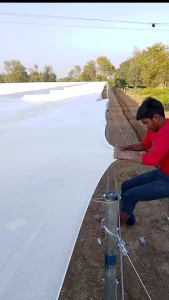 Worker Fixing Poly Film On Structure